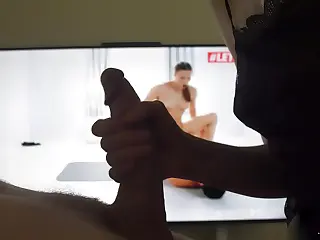 Une MILF avec des gros seins naturels et parfaits donne une pipe sensuelle en gros plan menant à un orgasme gâché, les écrans illuminés de porno en arrière-plan. La lueur subtile souligne les mouvements de lèvres, prolongeant un jeu qui titille à la limite. La libération s'échappe juste quand la tension atteint son comble, laissant une traînée de frustration et de délice persistants.